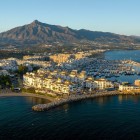 Puerto Banús si svela dall'alto tra yacht esclusivi, mare turchese e raffinata architettura mediterranea. Sullo sfondo, La Concha rende il panorama di Marbella ancora più spettacolare.