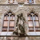 La statua di San Giorgio sulla facciata di Casa Botines a León raffigura il santo mentre sconfigge il drago, simbolo di coraggio e uno dei dettagli più iconici dell'opera di Gaudí.