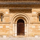 Il portale romanico della Chiesa di San Martín de Tours accoglie i pellegrini con eleganza senza tempo, tra raffinati dettagli scolpiti e pietra dorata dell'XI secolo.