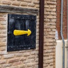 La freccia gialla del Cammino di Santiago indica la direzione ai pellegrini tra le vie di Sahagún, trasformando un semplice dettaglio urbano in simbolo di viaggio e scoperta.