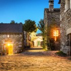 Le antiche case in pietra di O Cebreiro si illuminano al crepuscolo, creando un'atmosfera raccolta e suggestiva nel primo borgo della Galizia lungo il Cammino di Santiago.