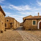 Una tranquilla strada acciottolata attraversa Castrillo de los Polvazares, tra antiche case in pietra e scorci autentici che custodiscono l'anima del Cammino di Santiago.