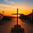 La Cruz de Ferro si staglia contro il tramonto a Foncebadón, uno dei luoghi più simbolici del Cammino di Santiago, dove ogni pellegrino lascia una pietra come segno di rinascita.