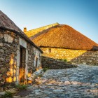 Le antiche pallozas in pietra di O Cebreiro, illuminate dalla luce del tramonto, custodiscono l'eredità celtica del borgo lungo il Cammino di Santiago.