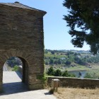L'antica Porta del Cammino accoglie i pellegrini all'ingresso di Portomarín, aprendo la vista sul fiume Miño e sul percorso che conduce verso Santiago de Compostela.
