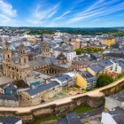 Veduta aerea del centro storico di Lugo, dominato dalla Cattedrale di Santa Maria e dalle imponenti mura romane Patrimonio UNESCO, tra i simboli più affascinanti della Galizia.