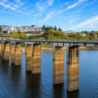 Veduta panoramica di Portomarín sul fiume Miño, con il ponte che attraversa il bacino della diga di Belesar e il borgo storico, tappa simbolo del Cammino di Santiago.