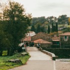Lo storico ponte sul fiume Furelos conduce i pellegrini verso il Cammino di Santiago, tra antiche case in pietra che custodiscono l'anima più autentica di Melide.