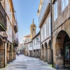 Nel centro storico di Santiago de Compostela, Rua Nova conduce alla Chiesa di Santa María Salomé tra portici in pietra e scorci ricchi di fascino medievale.