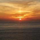 Il sole tramonta sull'Oceano Atlantico a Capo Finisterre, regalando uno spettacolo di luce e colori che da secoli affascina pellegrini e viaggiatori.