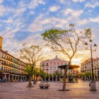 La Plaza Mayor di Segovia si illumina al tramonto, tra portici storici, eleganti palazzi e alberi che incorniciano una delle piazze più autentiche e affascinanti della Castiglia.