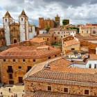 Dai tetti in coppi del centro storico di Cáceres emergono la Concattedrale di Santa María e le antiche torri nobiliari, simboli della città Patrimonio UNESCO dell'Estremadura.