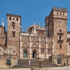 La facciata gotico-mudéjar del Monastero Reale di Santa Maria di Guadalupe domina la piazza del borgo, tra torri merlate e raffinati dettagli scolpiti in Estremadura.
