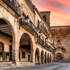I portici in pietra di Trujillo guidano lo sguardo verso la chiesa di San Martín, mentre la luce del tramonto valorizza archi, logge e facciate storiche dell’Estremadura.