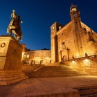 La luce serale avvolge la Plaza Mayor di Trujillo, dove la statua equestre di Francisco Pizarro dialoga con la chiesa di San Martín e le architetture storiche illuminate.
