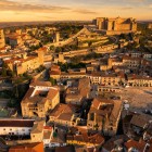 Trujillo si svela dall’alto con la Plaza Mayor rinascimentale, i palazzi nobiliari e il castello di origine islamica, collegato all’antica cinta muraria da torri e camminamenti medievali.