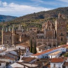 Il borgo di Guadalupe si raccoglie attorno al Real Monasterio de Santa María, complesso gotico-mudéjar che domina i tetti bianchi, incorniciato dai rilievi dell’Estremadura.