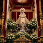 La Vergine Nera di Guadalupe domina l'altare maggiore del Monastero Reale, tra candelabri, fiori e preziosi drappi, simbolo della devozione mariana dell'Estremadura.