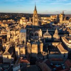 La Cattedrale di Toledo domina il centro storico con la torre gotica, le cappelle e gli archi rampanti, mentre la luce del tramonto riscalda il fitto intreccio dei tetti cittadini.