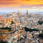 Dall’alto, Toledo rivela il suo cuore medievale: tetti in terracotta, antiche chiese e la Cattedrale emergono nel fitto centro storico, acceso dalle sfumature del tramonto.
