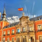 La facciata del Palacio de Santa Cruz esprime il rigore della Madrid asburgica: mattoni rossi, granito, balconi regolari e un portale scolpito coronato dallo stemma reale.