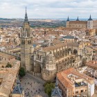 Vista dall’alto, la Cattedrale Primaziale domina il centro storico di Toledo con la torre gotica e l’ampia navata, mentre l’Alcázar emerge sullo sfondo tra i tetti castigliani.