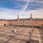 Plaza Mayor svela il cuore della Madrid degli Asburgo: portici continui, facciate in mattoni e torri della Casa de la Panadería circondano la statua equestre di Filippo III.