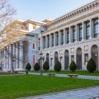 Il prospetto laterale del Museo del Prado distende portici e lesene neoclassiche lungo il giardino; il ritmo regolare della pietra rivela il progetto illuminista di Villanueva.