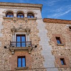 La Casa de Cisneros, palazzo plateresco del 1537, alterna muratura, mattoni e granito; balconi, cornici scolpite e loggia superiore narrano la storica Madrid rinascimentale.