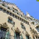 Vista dal basso lungo la Passeig de Gracia, Casa Amatller esalta la sua facciata modernista con richiami neogotici, decorata da graffiti, balconi in ferro battuto e raffinati dettagli scolpiti.