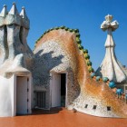 La terrazza di Casa Batlló rivela l’universo organico di Gaudí: il camino scultoreo, le superfici in trencadís e la croce a quattro bracci animano il tetto ispirato al drago.