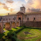 Il Castello di Montjuïc conserva l’aspetto della fortezza settecentesca: bastioni in pietra, fossato, ponte d’accesso e geometrie difensive raccontano il passato militare di Barcellona.
