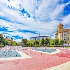 Plaça de Catalunya apre il cuore di Barcellona con fontane, aiuole e pavimentazioni geometriche, circondata da eleganti palazzi tra il centro storico e l’Eixample.