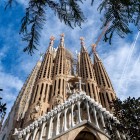 Dal basso, la facciata della Natività della Sagrada Família innalza le torri traforate di Gaudí sopra un ricco apparato scultoreo, dove architettura, natura e fede si fondono.