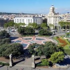 Dall’alto, Plaça de Catalunya rivela fontane, giardini e viali geometrici, cuore urbano di Barcellona e punto d’incontro tra la città storica e l’Eixample modernista.