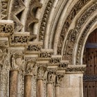 La Porta del Palau, ingresso romanico della Cattedrale di Valencia, affascina con archivolti scolpiti e capitelli istoriati che custodiscono simboli e figure del XIII secolo.