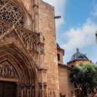 La Porta degli Apostoli rivela il volto gotico della Cattedrale di Valencia: archivolti scolpiti e rosone dialogano con la cupola e il Miguelete, simboli del centro storico.
