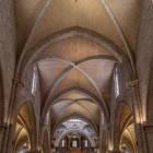 La navata della Cattedrale di Valencia conduce verso l’altare tra pilastri slanciati, archi ogivali e volte a crociera, testimonianza dell’elegante architettura gotica del XIII secolo.