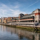 Affacciato sulla Ría di Bilbao, il Mercado de la Ribera unisce architettura Art Déco, ampie vetrate e tradizione gastronomica nel cuore dello storico Casco Viejo.