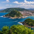Dal Monte Igueldo, la vista abbraccia l’isola di Santa Clara, il promontorio di Urgull e San Sebastián, tra baie luminose, colline verdi e acque del Mar Cantabrico.