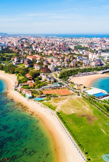 Vista aerea di Santander, capoluogo della Cantabria, tra spiagge dorate, acque del Mar Cantabrico e quartieri costieri, dove paesaggio urbano e natura si incontrano.