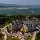 Vista aerea del Palacio de la Magdalena, antica residenza reale dall’architettura eclettica, tra giardini, pinete e la baia di Santander affacciata sul Mar Cantabrico.
