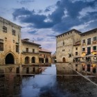 Al tramonto, la piazza medievale di Santillana del Mar si riflette sul selciato bagnato. Nel cuore della Cantabria, il borgo è una suggestiva tappa del Cammino del Nord.