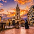 Al tramonto, la Cattedrale di San Salvador domina il cuore di Oviedo: la torre gotica svetta sulla piazza accanto alla Regenta, simbolo letterario della città asturiana.