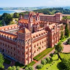 L’Universidad Pontificia domina Comillas tra torri, mattoni e richiami neogotici e modernisti, circondata da giardini e dal verde paesaggio della costa cantabrica.