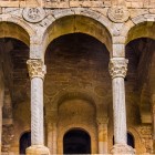 Nel belvedere di Santa María del Naranco, tre arcate aprono lo sguardo sul paesaggio: colonne, capitelli e medaglioni scolpiti rivelano la raffinatezza della corte di Ramiro I.