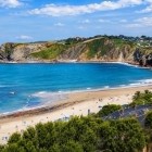 Playa de Comillas si apre sul Cantabrico tra sabbia dorata, acque azzurre e scogliere verdi, regalando una passeggiata panoramica lungo uno dei tratti più suggestivi della costa.