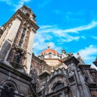 In Plaza Fernando Rubio, la Basilica di San Juan el Real, progettata da Luis Bellido e inaugurata nel 1915, fonde forme neoromaniche e bizantine tra torri e cupola rossa.