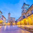 Da una prospettiva laterale, Plaza de la Constitución guida lo sguardo tra i portici del Municipio e la torre di San Isidoro, nel cuore civico e religioso della Oviedo storica