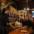 In una tipica sidrería asturiana di Oviedo, l’escanciado trasforma la degustazione del sidro in un rito conviviale, tra botti in legno, sapori locali e un’atmosfera autentica.